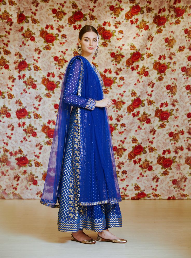 Editor's Note This set features a royal blue embroidered long kurta with dupatta and trouser. Color: Royal Blue Fabric: Silk Chnderi Brocade And Georgette Embroidery Details: Zardozi Care: Dry Clean Only Customize Your Outfit Can't find the size you're looking for? No stress. Just select the size "Custom" while adding the item to your cart. We will follow up with you for your body measurements. To request a color or design customizations, please contact our customer care by using our "Ask us a q Designer Royal Blue Salwar Kameez For Eid, Royal Blue Semi-stitched Set For Eid, Semi-stitched Royal Blue Salwar Kameez With Resham Embroidery, Semi-stitched Royal Blue Bollywood Anarkali Set, Blue Unstitched Sets With Mirror Work, Eid Royal Blue Anarkali Set With Resham Embroidery, Eid Blue Embroidered Anarkali Set, Blue Anarkali Embroidered Sharara, Royal Blue Unstitched Kurta With Dupatta