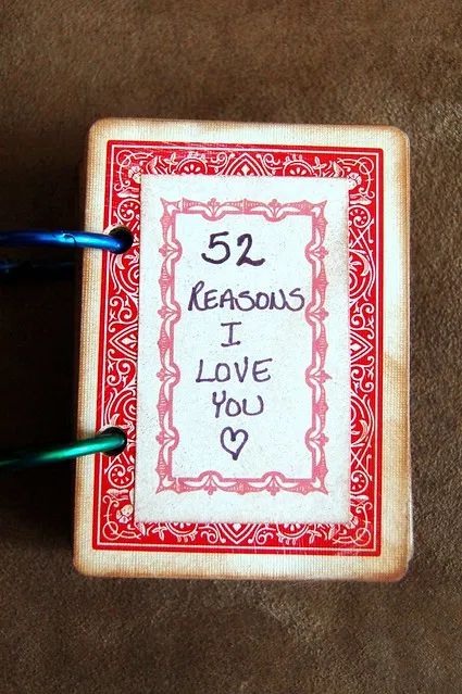 a small book with writing on it and two blue pens in front of the cover that says, 52 reasons i love you