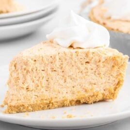 a piece of cheesecake on a plate with whipped cream