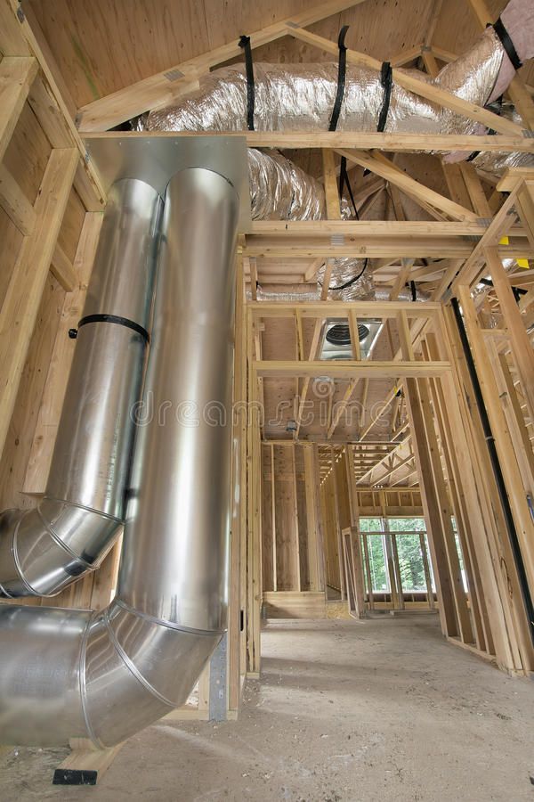 an unfinished house with pipes and wood framing