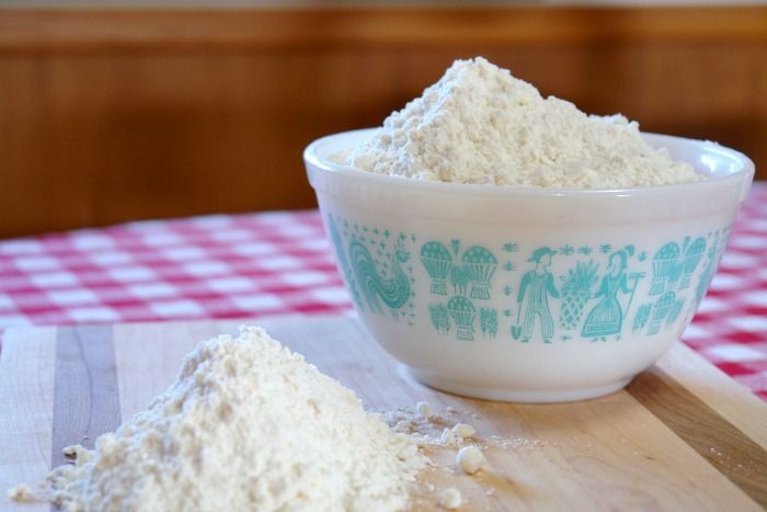 a bowl filled with flour sitting on top of a wooden cutting board