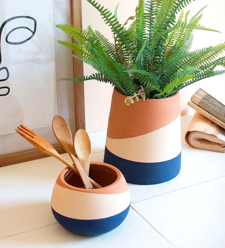 two pots with plants and wooden spoons in them