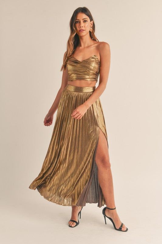 This Isabella Skirt Set features a stunning foil lamay fabric, with the classic two-piece set design. It is perfect for high fashion occasions and provides a stylish look. The maxi split skirt has a beautiful side split, giving it a sophisticated, contemporary edge. 96% Polyester 4% Spandex Chic Metallic Skirt For Night Out, Chic Gold Maxi Dress, Flowy Maxi Skirt For Night Out, Party Skirt With Side Slits And Asymmetrical Cut, Glamorous Maxi Skirt For Party Season, Chic Gold Maxi Dress For Date Night, Elegant Split Skirt For Party, Chic Metallic Lined Skirt Bottoms, Chic Metallic Bottoms With Lined Skirt