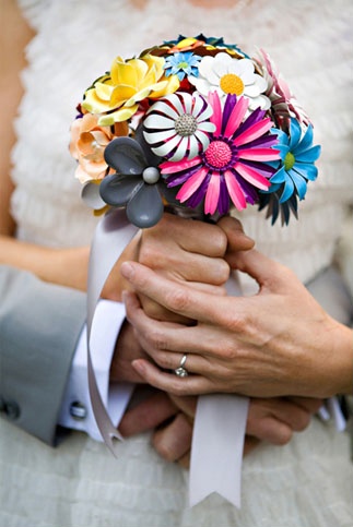 the bride and groom are holding each other's colorful bouquet