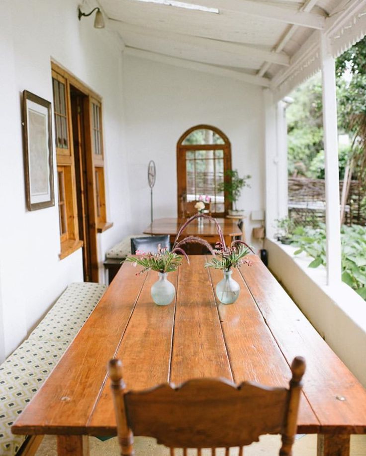 a long wooden table with two vases on it