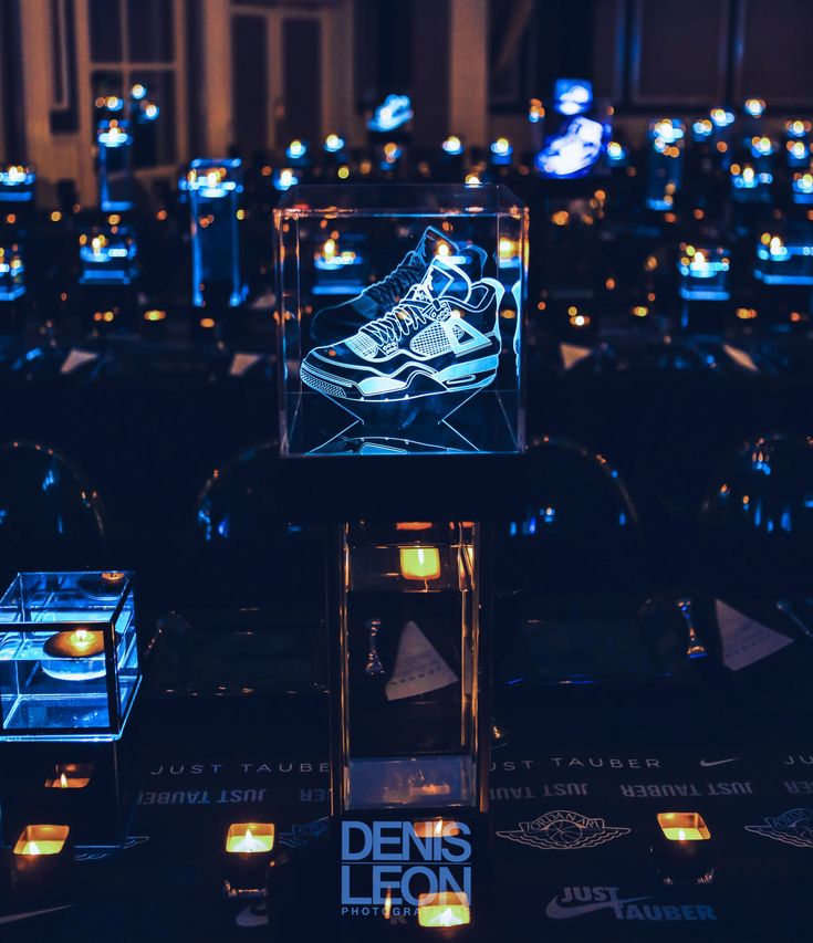 a lighted display case in the shape of a sneaker on top of a table