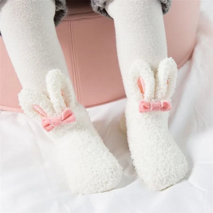 Embrace the coziness of winter with our adorable Bunny Baby Socks, designed to keep your little one's feet warm and stylish. Perfect for indoor lounging or outdoor adventures, these socks feature a soft, fluffy exterior and lining, ensuring maximum warmth and comfort. Adorned with a cute bunny face and ears on the top, a bow at the front, and playful pom poms, these socks are as charming as they are practical.Made with a cozy fleece material, these socks provide a soft and gentle touch against your baby's skin, keeping their feet warm and snug during the colder monthsThe socks boast a delightful bunny face and ears on the top, bringing a whimsical touch to your baby's winter wardrobe.A cute bow at the front and pom poms at the opening add playful elements to the socks, making them a joy to Bunny Ears And Tail, Vogue Kids, Fluffy Bunny, Rabbit Baby, Toddler Socks, Pink Socks, Bunny Face, Soft Cute