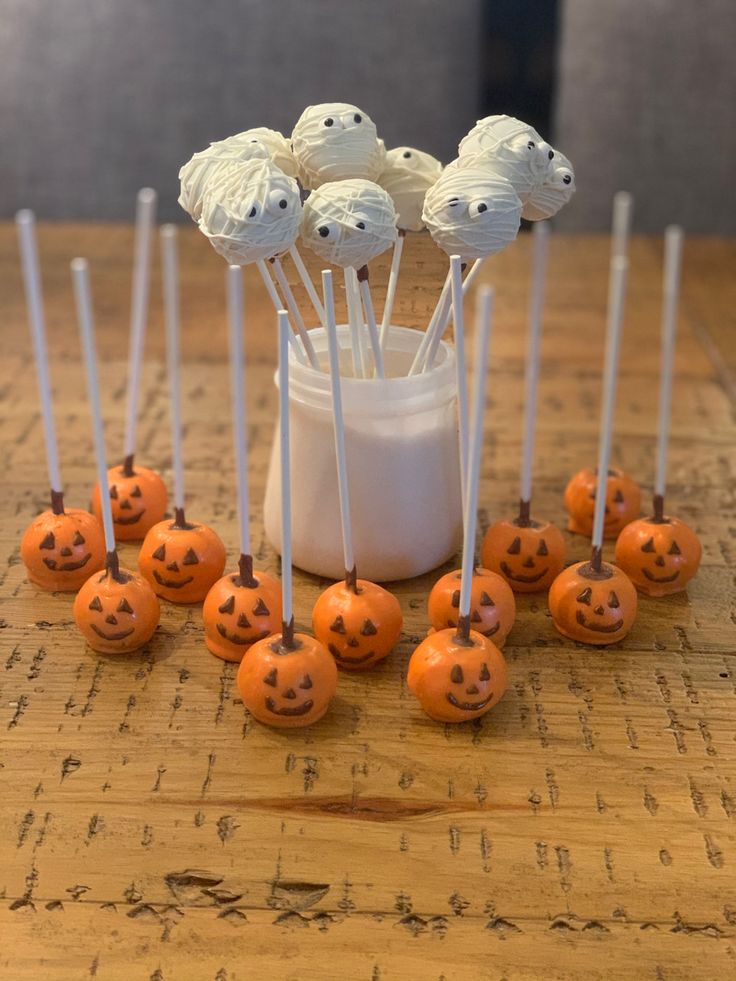 there are many pumpkins on the table with marshmallows sticking out of them