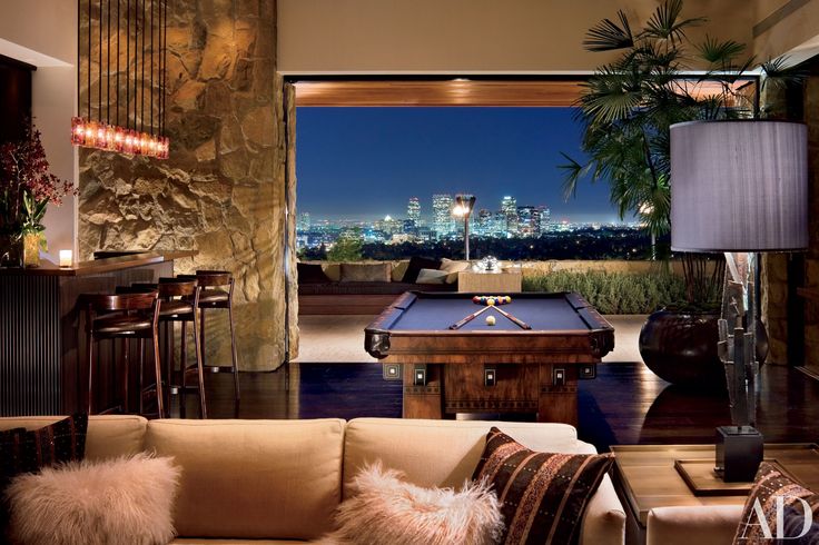 a living room filled with furniture and a pool table in front of a large window