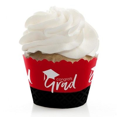 a cupcake with white frosting and graduation cap on it's wrapper