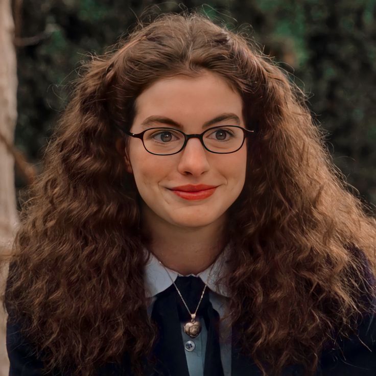 a woman with long hair and glasses smiling