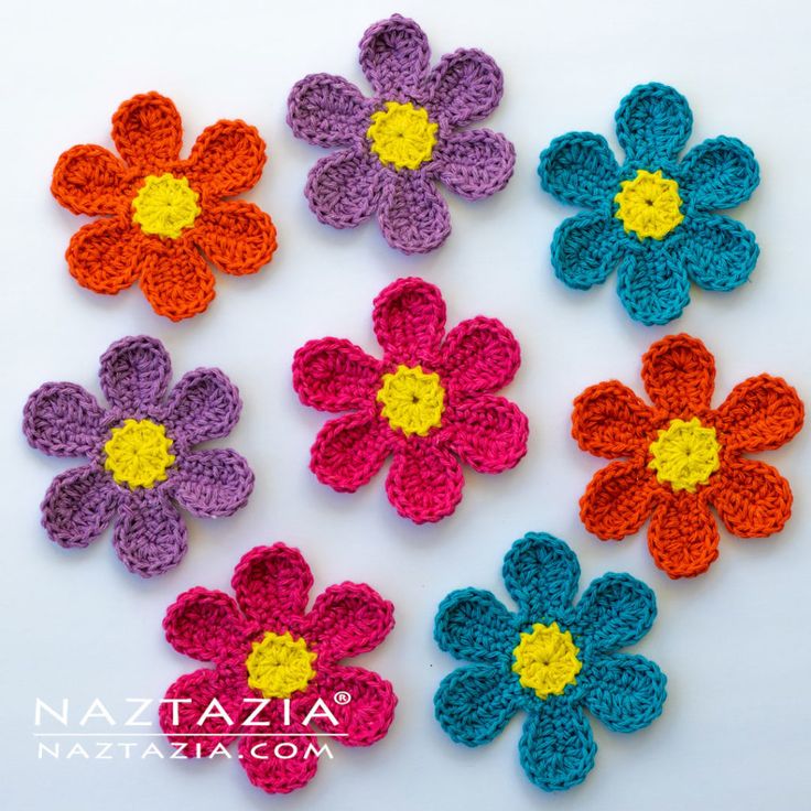 crocheted flowers are arranged on a white surface