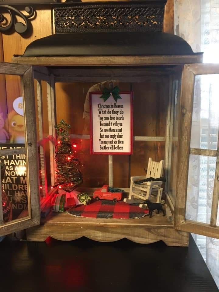 an old fashioned christmas lantern with a sign on it's front and side window