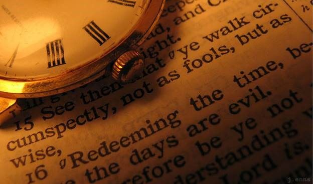 a close up of a watch on top of an open book with the word time