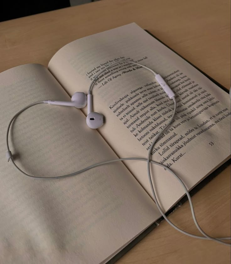 an open book with headphones on top of it