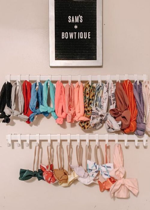 there are many scarves hanging on the wall and one is in front of a sign that says sam's bowtiquee