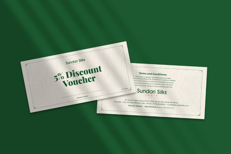 two coupons sitting next to each other on top of a green surface with the words discount voucher written below them