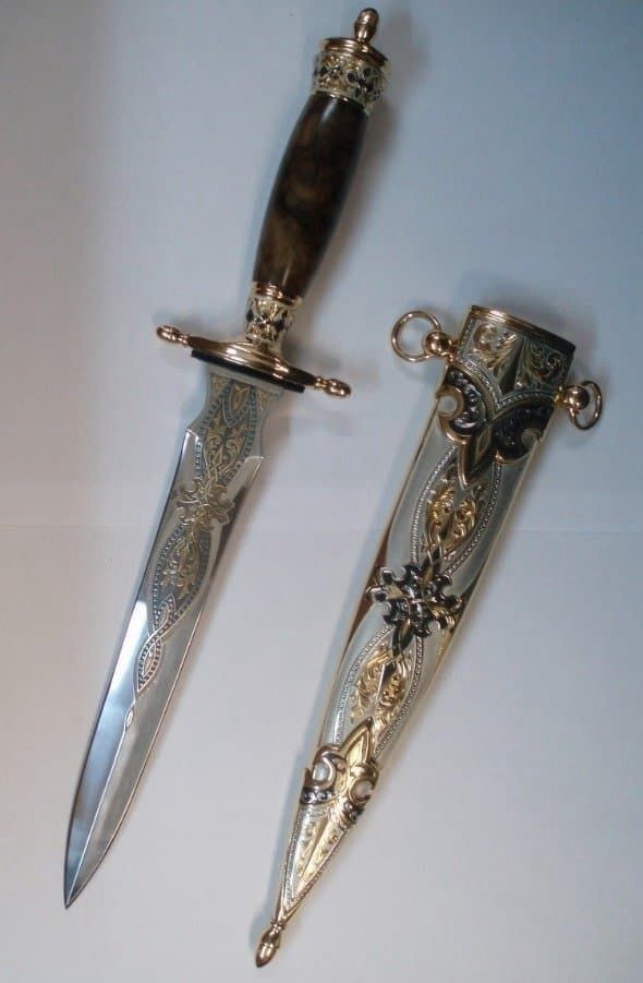 two knives are sitting next to each other on a white surface with an intricate design