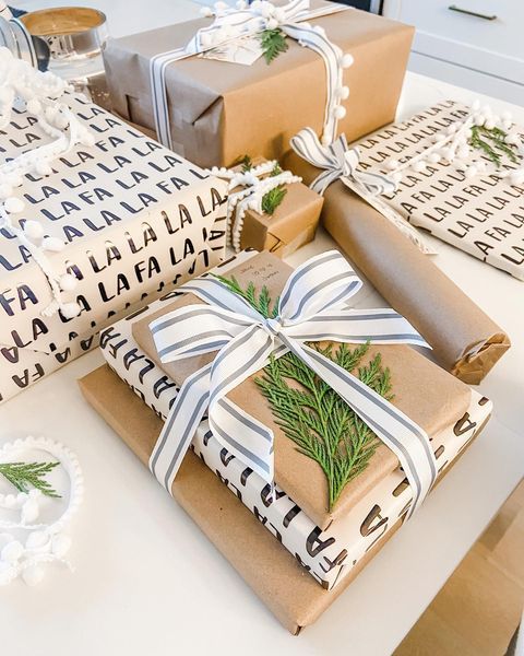 presents wrapped in brown paper and tied with white ribbon are sitting on a counter top