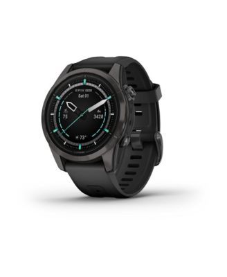 the garmin watch is shown in black with green accents and an analog display on its face