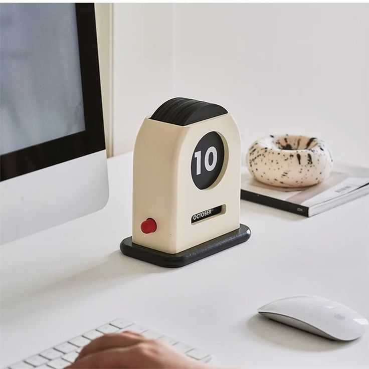 a desk with a computer, mouse and other items on the table in front of it