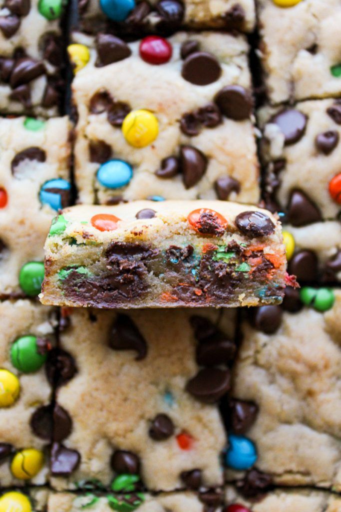 a cookie bar with chocolate chips and m & m candy bars on it's side