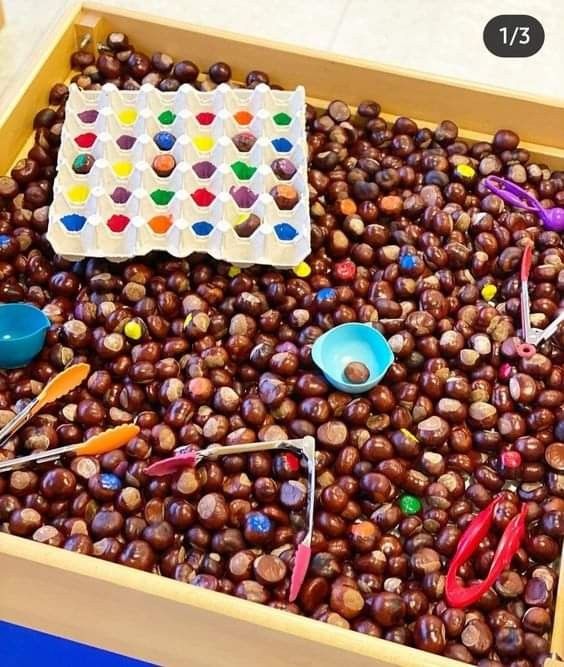 a wooden box filled with lots of beads and scissors on top of a table next to a sheet of paper