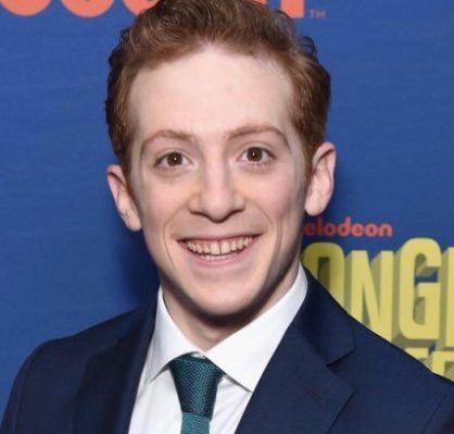 a smiling young man in a suit and tie