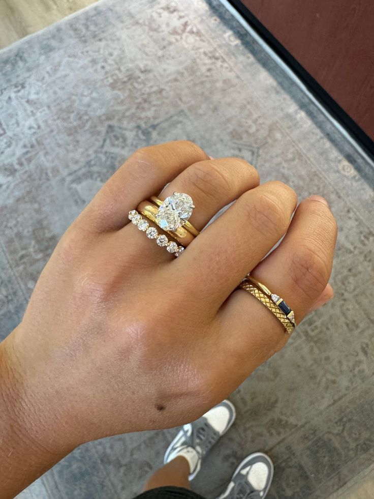 a person's hand with two different rings on their fingers and one is holding the other