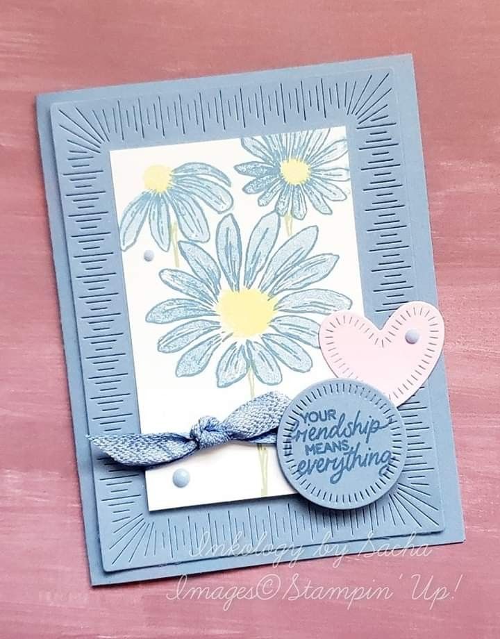 a close up of a greeting card with flowers on the front and blue ribbon around it