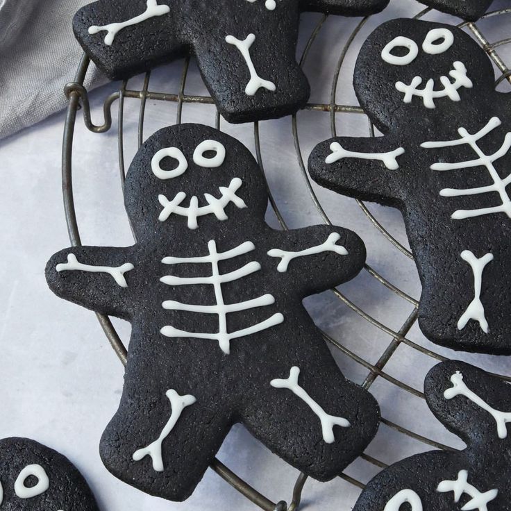 some cookies decorated with icing are sitting on a wire rack and ready to be eaten