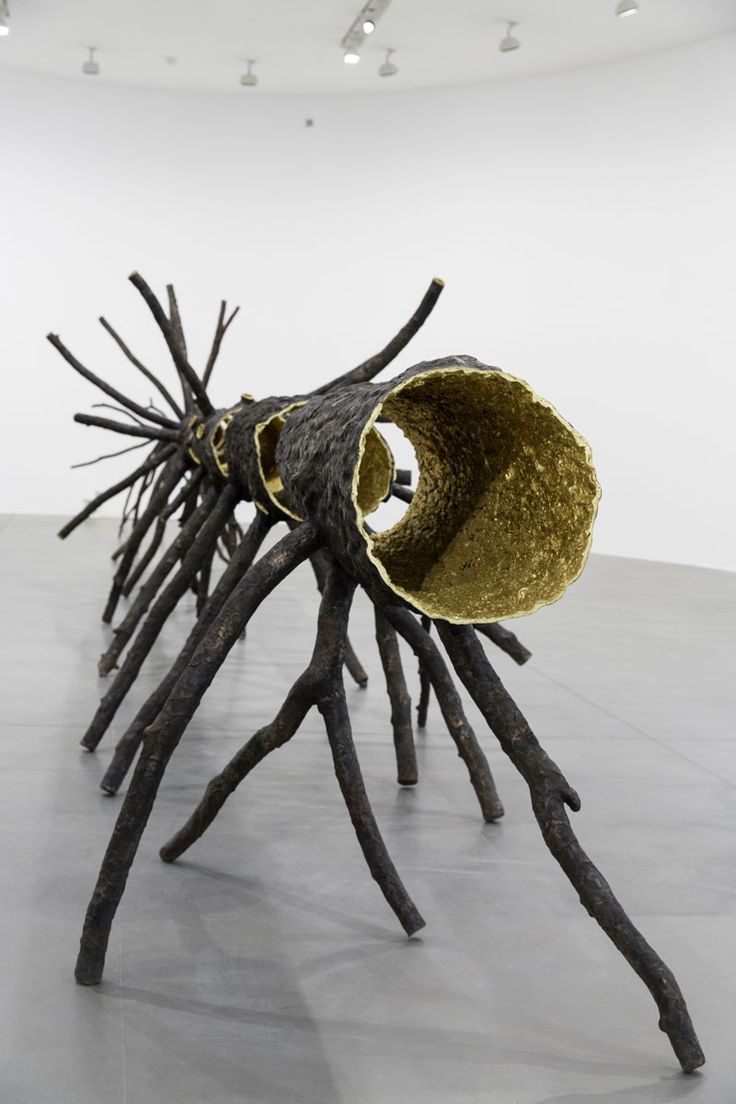 a sculpture made out of sticks with a large object in the middle