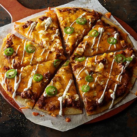 a pizza sitting on top of a pan covered in cheese and green pepper toppings