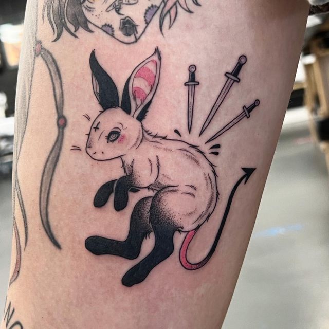 a tattoo with an image of a rabbit and other animals on it's leg