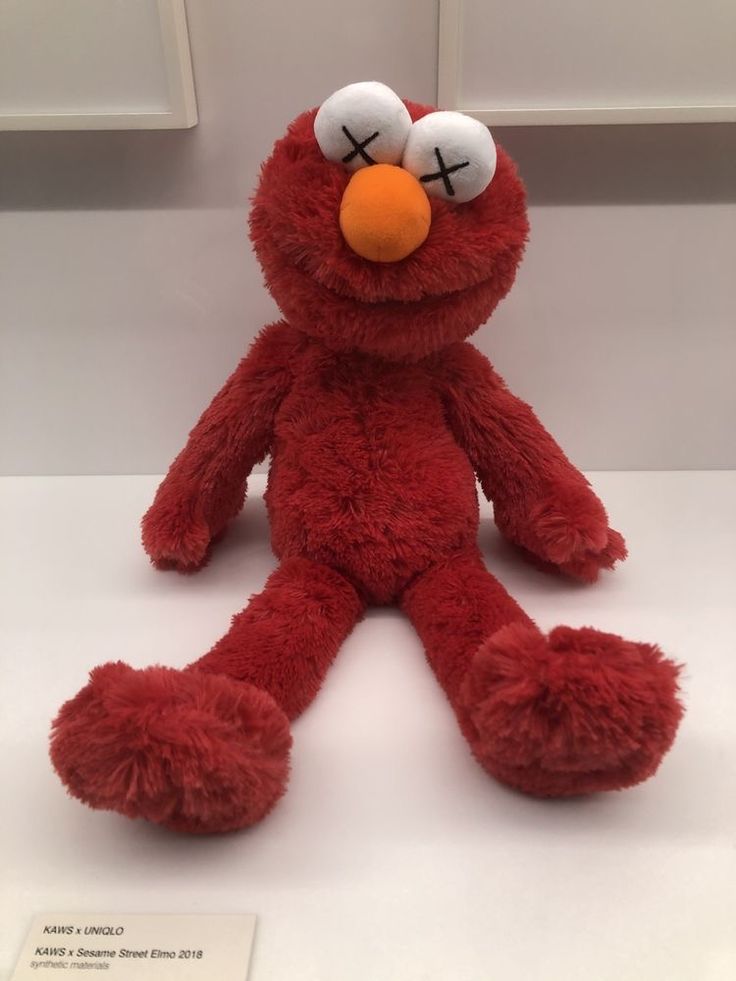 a red stuffed animal sitting on top of a white counter