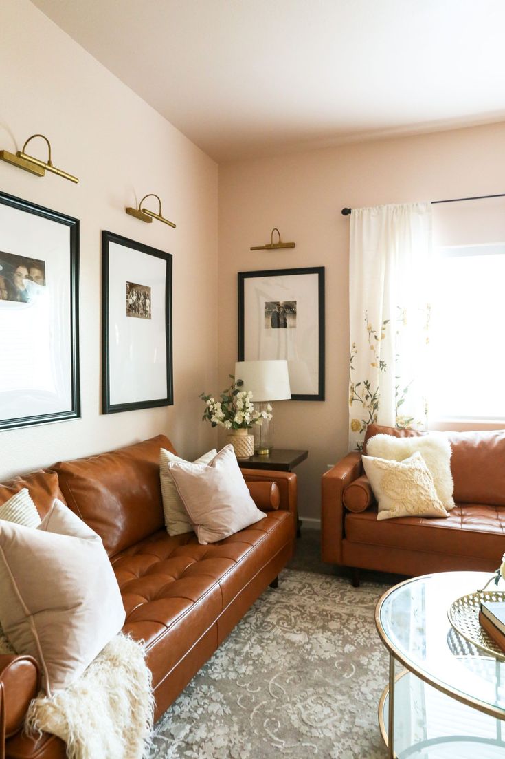 a living room with two couches and pictures on the wall above them, along with a coffee table