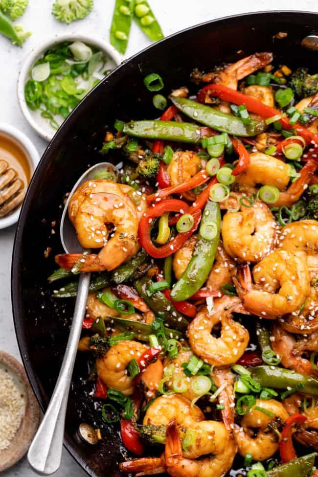 a skillet filled with shrimp and vegetables