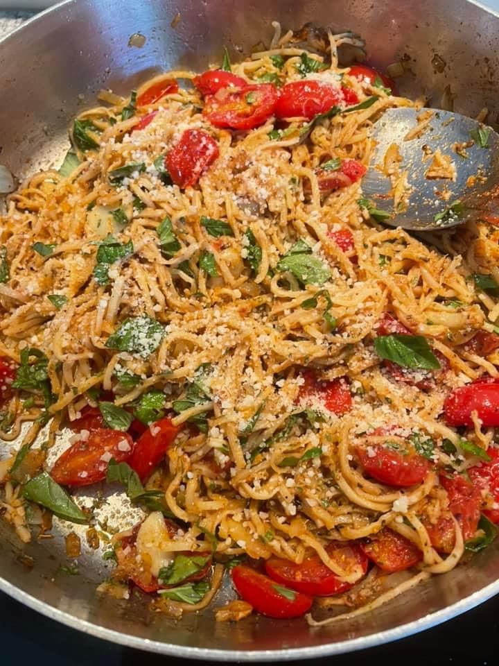 a pan filled with pasta and vegetables on top of a stove