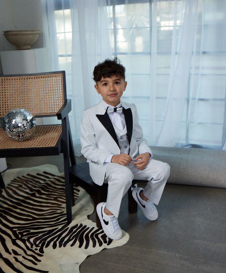 5 Piece Fashion Sequin Tuxedo Set dapper your little gentleman right up! This look is smoother than sequins with its glitter finish.  Talk about wanting to be the star of the occasion, or even just a little bling bling. Boy's 5-Piece Fashion Sequin Tuxedo Set consists of a high quality jacket, a double breasted vest, pants, shirt and bowtie.  Peak Lapel Jacket offers side vents for ventilation and comfort. Comes with matching pants. Pants need to be hemmed/tailored to match his height.  Modern Sequin Tuxedo Set is European Cut which makes it really slim, so please keep allowances in mind. Whatever the occasion, may it be a part, a wedding, or even just another day out and about- we are here for the moments for that matter! Classic White Sets For Black Tie Occasions, Fitted White Sets With Bow Tie, White Fitted Sets With Bow Tie, Fitted White Bow Tie For Black Tie Occasions, Fitted White Bow Tie For Black Tie Events, Tailored Tuxedo Sets For Ceremony, White Fitted Bow Tie For Black Tie Events, White Tuxedo Three-piece Suit For Party, White Tuxedo Set For Party