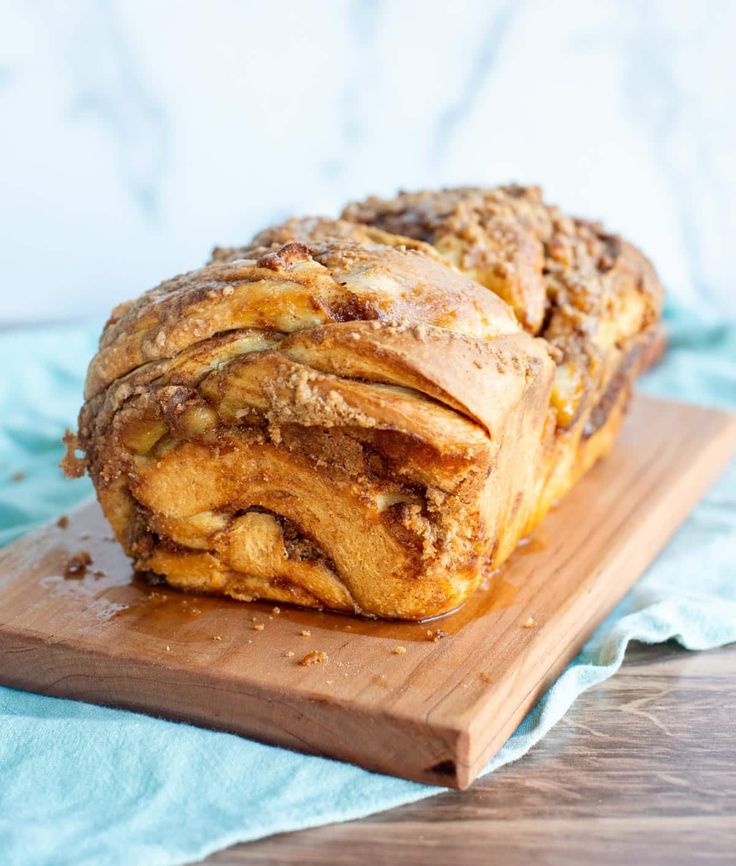 a loaf of bread sitting on top of a wooden cutting board