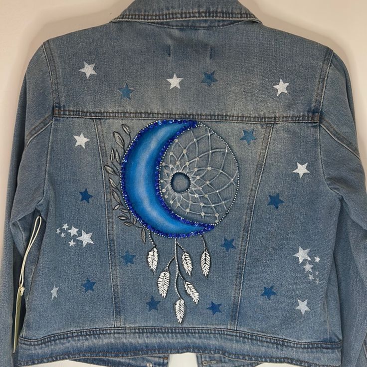 a denim jacket with stars and a moon on it