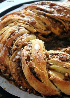 a bundt cake sitting on top of a pan covered in chocolate sauce and nuts