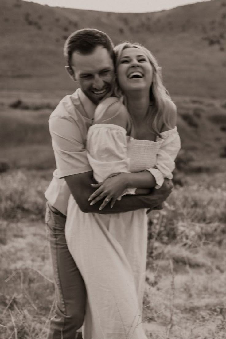 a man and woman hugging each other in the desert