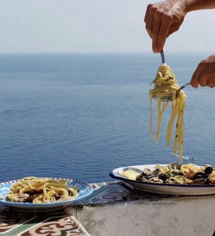 a person is eating some food by the ocean