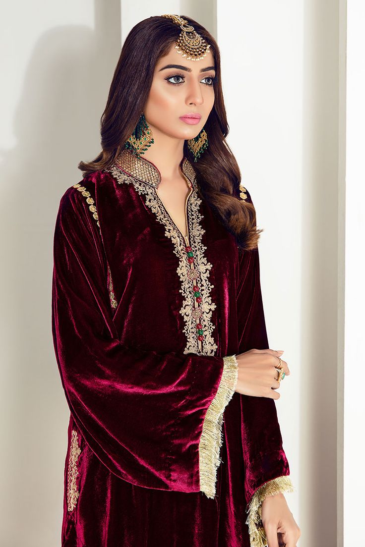 Maroon velvet shirt with embellished ban and embroidery on neck. Comes with plain pants and chiffon dupatta. Velvet Frocks For Women, Velvet Shirts, Velvet Kurti, Bridal Anarkali Suits, Velvet Suit Design, Pakistani Kurta, Girls Winter Dresses, Sew Patterns, Dresses Velvet