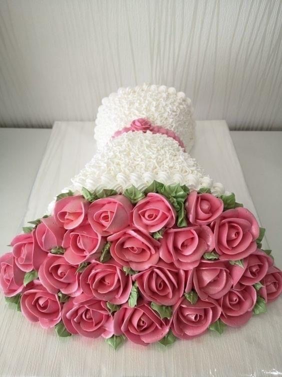 a wedding cake with pink roses on top