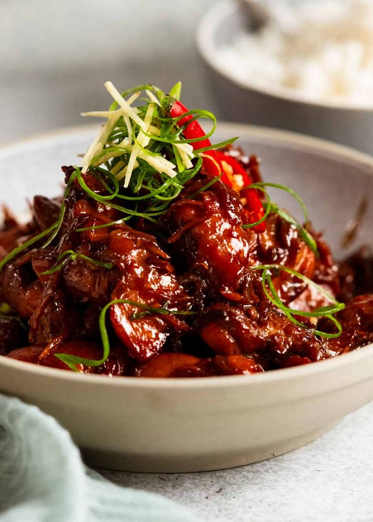 a close up of a bowl of food with meat and vegetables on the top of it