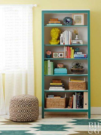 a blue bookcase with books and baskets on it