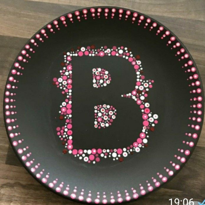 a black plate with pink and white polka dots on the letter b in the center