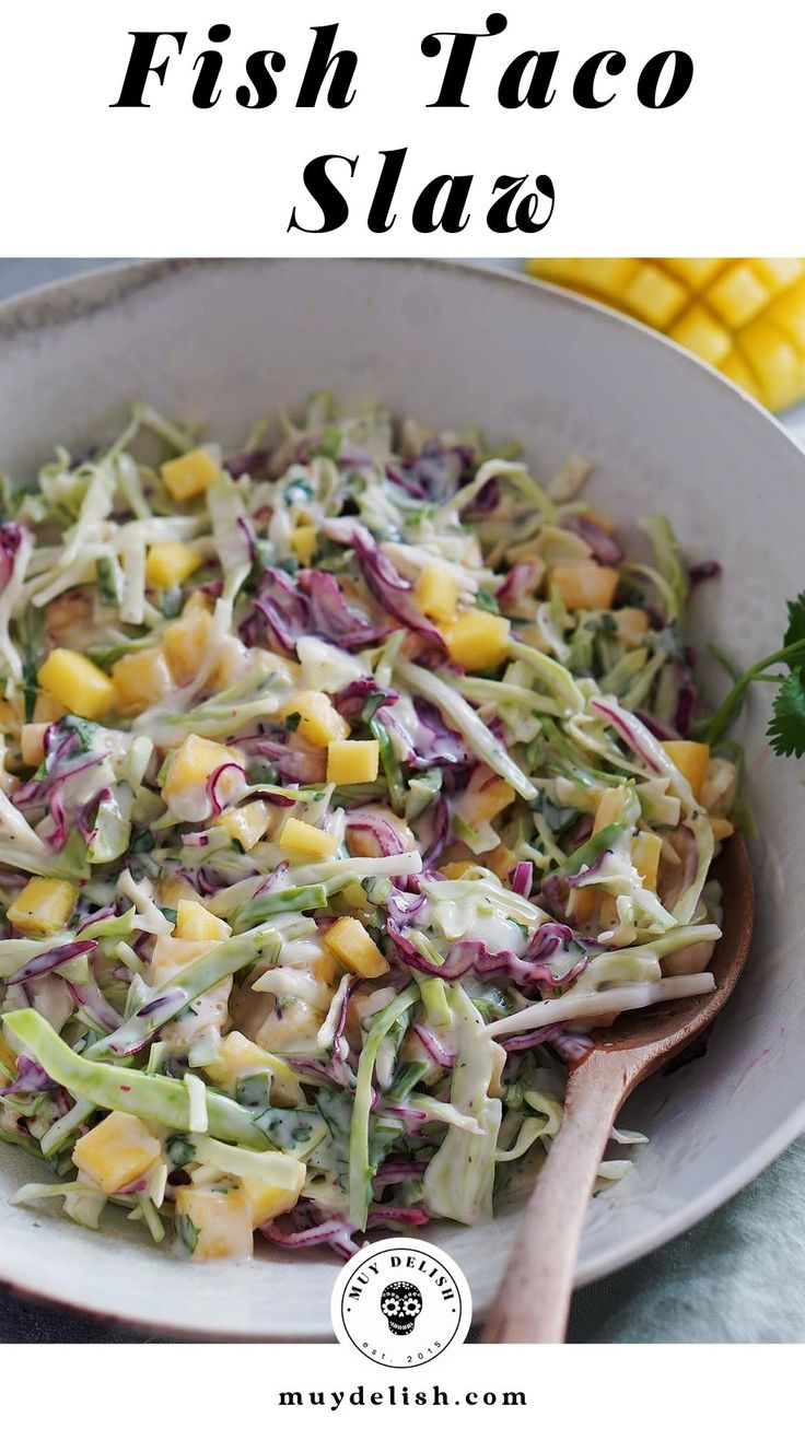 a white bowl filled with coleslaw next to corn